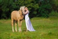 Rider woman blonde with long hair in a white dress with a train posing on a palamino horse Royalty Free Stock Photo