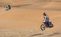 Riders on dirt bikes in a desert