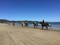 Riders on horseback on 90 Mile Beach, Ahipara, New Zealand