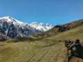 Riders on horseback ride in the mountains during the daytime rear view