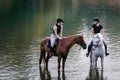 Riders, two young women riding horses down the river Royalty Free Stock Photo