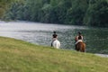 Riders, two young women riding horses down the river Royalty Free Stock Photo