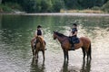 Riders, two young women riding horses down the river Royalty Free Stock Photo