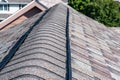 Ridge cap vent installed on a shingle roof for passive attic ventilation on a residential house. Royalty Free Stock Photo