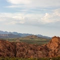 A red sandstone ridge rises above the desert floor outside of Hurricane Utah with Pine Valley Mountain in the distance. Royalty Free Stock Photo