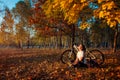 Riding bicycle in autumn forest. Young woman biker relaxing after exercising on bike. Healthy lifestyle Royalty Free Stock Photo