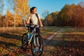 Riding bicycle in autumn forest. Young woman having rest after workout on bike enjoying nature. Healthy lifestyle Royalty Free Stock Photo