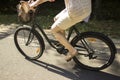 Riding bicycle on the forest road. Close-up of young woman riding bicycle. Royalty Free Stock Photo