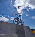 Riding, bike and teen on ramp for sport performance or event at park in summer with blue sky mockup. Bicycle, stunt or Royalty Free Stock Photo