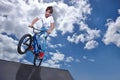 Riding, bike and teen on ramp for sport performance, jump or training for event at park with blue sky mockup. Bicycle