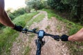 Riding a black mountain bike with nav on a gravel mountain road from a rider chest point of view