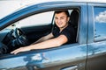 Riding his new car. Side view of handsome young man driving his car and smiling Royalty Free Stock Photo