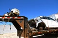 Riding lawn mower and wrecked car on a trailer Royalty Free Stock Photo