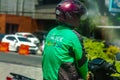 An online motorcycle taxi driver with a cellphone is placed on the dashboard of a motorcycle. SLEMAN, INDONESIA - OCTOBER 20, 2021