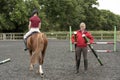 Riding school pupil and instructor Royalty Free Stock Photo