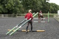 Riding school pupil and instructor with poles for a jump Royalty Free Stock Photo