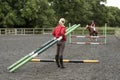 Riding school pupil and instructor with poles for a jump Royalty Free Stock Photo