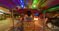 Riding Tuk tuk driving on street road, Thai traditional native taxi at night in Bangkok City, Thailand in holiday vacation travel Royalty Free Stock Photo