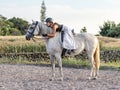 Riding white Lusitano horse, outdoors, cute team, riding arena outside