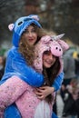 Girls wearing a unicorn costume smiling in the street during the carnival