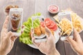 Riends using smartphones to take photos of fried chicken and fre