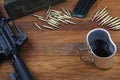 Rifle, ammunitions and cup of coffee on wooden table