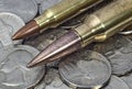 Rifle cartridges on a pile of American coins Royalty Free Stock Photo