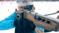 A rifle with its muzzle in the hands of a female biathlete