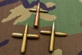 Rifle and pistol bullets gathered together in the shape of a cross. War concept. Military cloth background shot Royalty Free Stock Photo