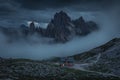 Rifugio Lavaredo mountain cabin with hiking trail in front of Dolomite Alps mountains with fog at Three Peaks in Italy from above Royalty Free Stock Photo