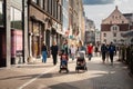 RIGA, LATVIA - AUGUST 21, 2023: Selective blur on a family mother father & kids in strollers, babies in a pedestrian street in
