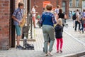 RIGA, LATVIA - AUGUST 18, 2018: A young guy on the street playing saxophone and earning money. Royalty Free Stock Photo