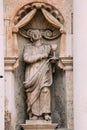 Riga Latvia. Close Ancient Statue Of Man With Bowl On Facade Of St. Peter Church,