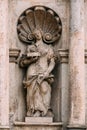 Riga Latvia. Close Ancient Statue Of Man With Lamb Lying On Book On The Facade Of St. Peter Church