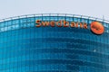 Riga Latvia. Close Blue Glass Facade Of Headquarter Of Swedbank With Red Signboard, Round Logotype