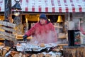 Riga / Latvia - 03 December 2019: Man in national costume cooking street food outdoor in traditional Christmas market food