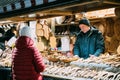 Riga, Latvia. Man Seller Sells Various Natural Wooden Crafts At Winter Christmas Market. Popular Souvenir From Baltic