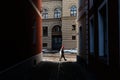 Riga / Latvia - 01 December 2019:View through Narrow medieval street. Aged tourist with stick walking in the old Riga city, Latvia