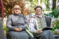 Couple of women in traditional clothes with hats and accordion