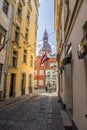 Riga, Latvia- July 7, 2023: Kramu Iela small historic cobbled street with a view of Riga Doma Cathedral