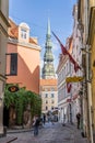 Riga, Latvia- July 7, 2023: Kramu Iela small historic cobbled street with a view of St. Peters Church