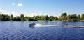 Riga, Latvia - July 17, 2020: Man on a board rushes down the Daugava River in Riga.Wake-board