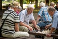 RIGA, LATVIA - JULY 18, 2018: Men seated on park benches and playing chess.