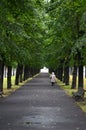 RIGA / LATVIA - July 26, 2013: Old woman is walking alone under the trees in a park