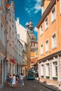 Riga, Latvia. People Walking On Narrow Cobbled Kramu Street Of Old Town With View Of Ancient Architectural Landmark Riga