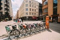 Riga, Latvia. Row Of Colorful Bicycles For Rent At Municipal Bike Parking In Kalku Street, Popular Showplace Of Old Town