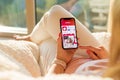 Riga, Latvia - July 21, 2018: Woman looking at Tinder dating app on mobile phone .