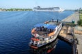 Riga, Latvia - May 21, 2016: Cruise Ship MSC Opera turning round and Touristic river boat with paddle wheel by the city Royalty Free Stock Photo