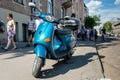 RIGA, LATVIA - MAY 24, 2014: Miera street Pentecost. Side of the street stands scooter. People walking down the street