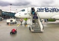 Passengers get off the Airbaltic plane arrived in Riga on a rainy day.
